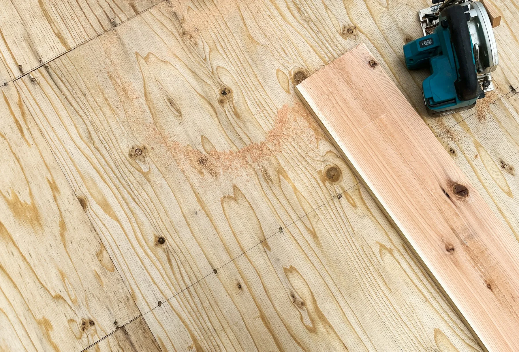 New wooden floorboards being cut and laid in a room